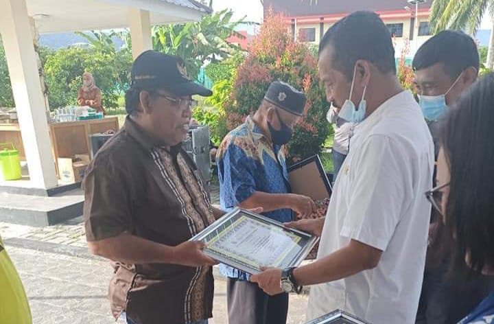 Kepala Dinas TPHP Kabupaten Banggai, Ir.Usman Suni,MM saat menyerahkan cendra mata kepada Kaslan Djano, seorang ASN penyuluh pertanian yang memasuki masa purna tugas.